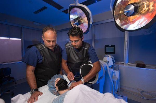 Dr. David Wells-Roth, Dr. Harshpal Singh with patient on operating room table