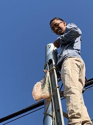 My brother working on installing hooks to hang lights.