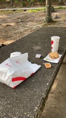 Picnic table with a full meal left behind.