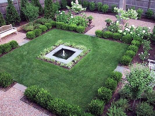 Formal city garden; green and white plantings; square bluestone-edged fountain; peastone walkway s and sitting areas edged in st