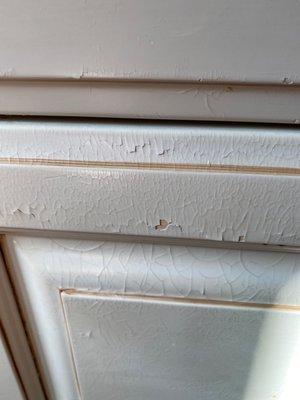 Cracked paint on all the cabinets.