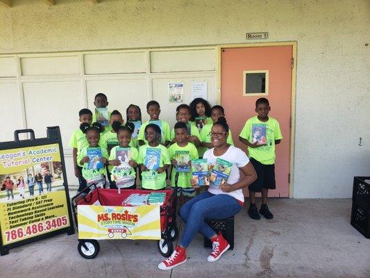 Ms. Rosie gives away books  to students at Meagan's Academic Center Summer Camp.