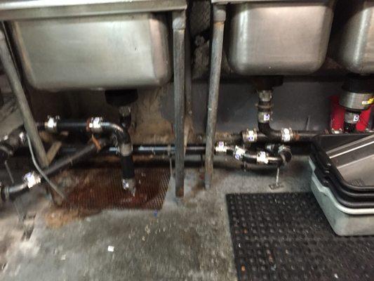 Commercial triple pot sink installation with sump pump and dual grease traps.