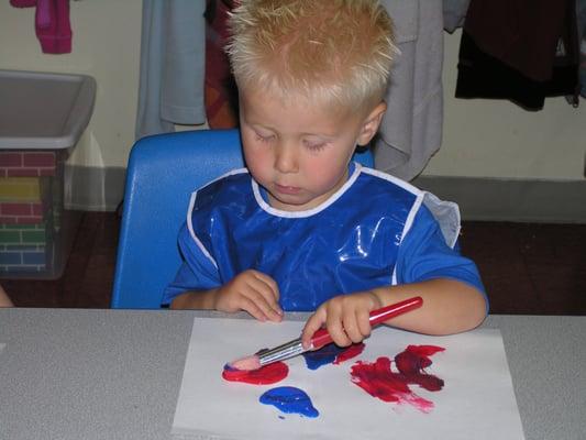 Toddler painting during arts and crafts