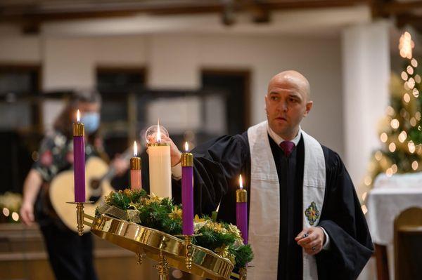 Rev. Jason Valendy lighting the Christ candle during Christmas Eve worship