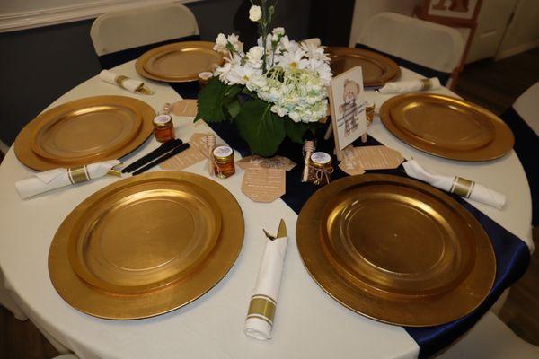 Table set up (silverware, centerpieces and favors from us, linens, gold plates and runners from them)