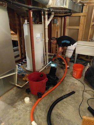 Using 'high suction' extraction to unclog a backed up return drain in the basement utility room.