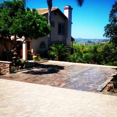 Stamped concrete parking area, faux rock walls around parking area