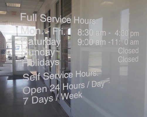 view of operational hours posted on window of Marion, Arkansas post office building