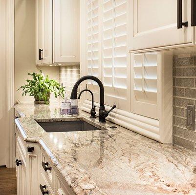 For this kitchen sink space, we designed an elegant Ogee edge profile and increased the depth of the kitchen base to accentuate the sink.