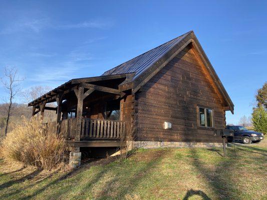 Noticed the barbecue grill and fire pit along the left side of the cabin.