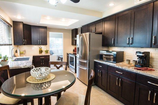 Oceanside Kitchen-Espresso cabinets. 
  Granite counter top with glass subway
  back splash.