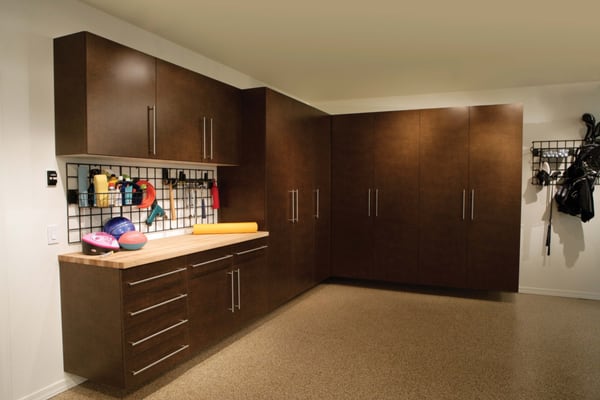 Bronze garage cabinets with epoxy flooring and grid wall.