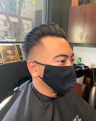 Mid-high skin-fade w/ a brush back style on top.