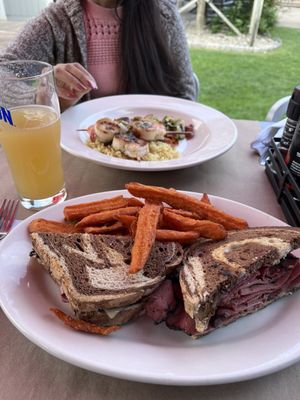 Shrimp and scallop skewers along with a pastrami sandwich.