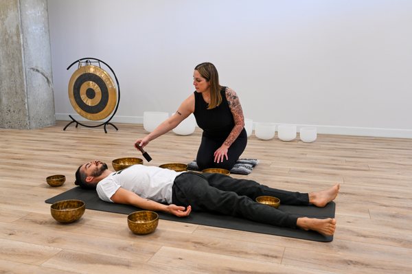 Singing bowls are played as part of a yoga therapy session.