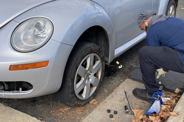 To start changing a tire, set up whatever jack you have available. It's ideal if you can lift the car from the frame or pinch weld.