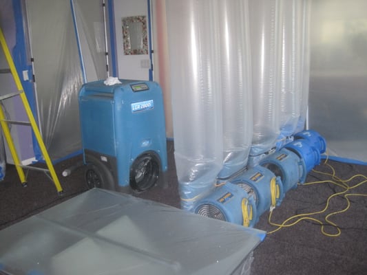 VIEW OF DEHUMIDIFIER AND AIR MOVERS WITH DUCTED AIRFLOW  INTO CEILING CAVITY DURING THE MITGATION PROCESS IN VALENCIA, CA