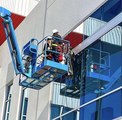 Exterior film application using a boom lift. Elevate your building's looks and energy savings. Contact us now!