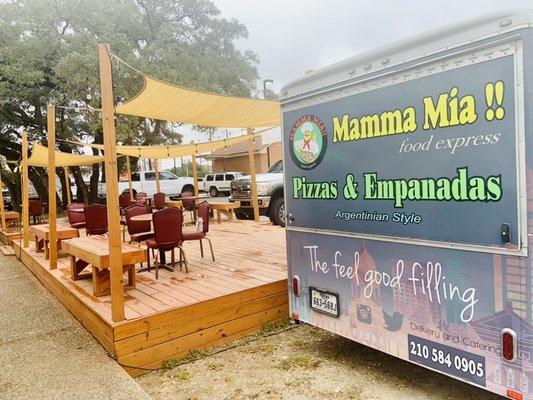 Food truck is conveniently parked along side a nice seated patio area for your enjoyment or take it to go