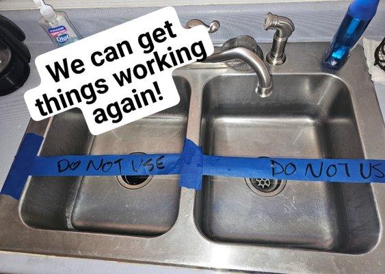 Kitchen sink blocked off with tape that reads "do not use" because it wasn't draining.