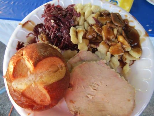 Slice pork with red cabbage, spaetzle, and pretzel bread