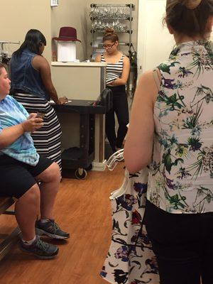 Both fitting room attendants professionally playing on their cell phones.