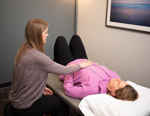 Physical Therapist assessing teaching exercise for pelvic health.