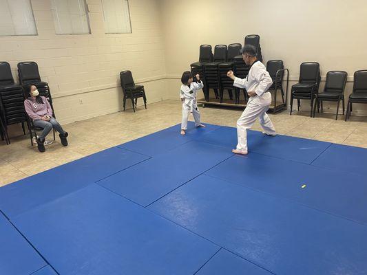 Grandmaster Kim training student in hammer blocking technique