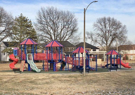 The playground has a synthetic surface.