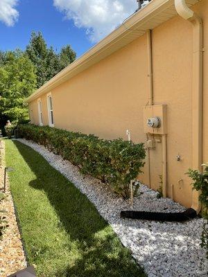 White marble stone wrapping the entire property with freshly hedged shrubs