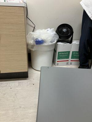 Trash can overflowing in side room