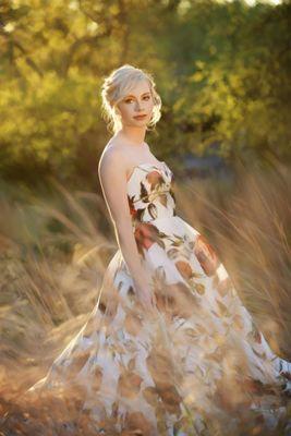 a high school senior girl in a field of tall gold grass at sunset, Wimberley TX - painted portrait