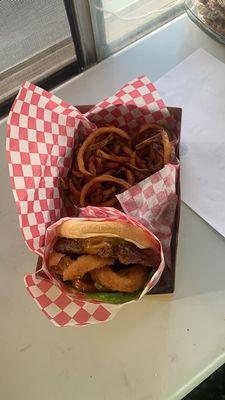 Bacon cheeseburger with onion rings and hand cut curly fries