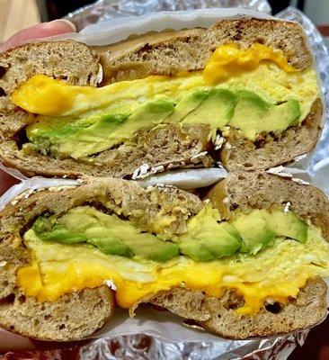 Egg & cheese with avocado on a multigrain bagel, scooped out.