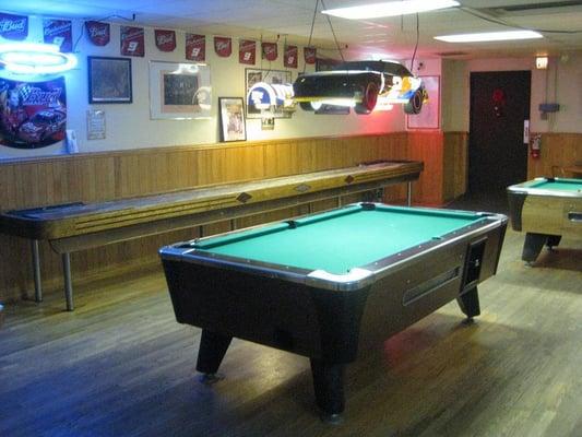 A pool table and shuffle board in the back room