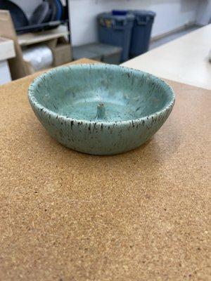 A finished incense holder on speckled clay with a turquoise dipping glaze