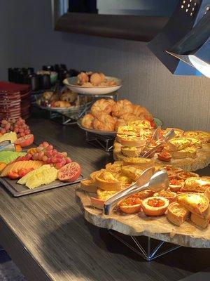 Breakfast bar with fruit display and mini assorted quiche.