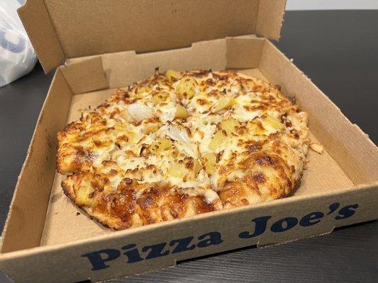 Small BBQ chicken pizza with pineapples.