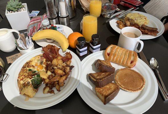 Omelette, bacon, sausage, French toast, pancake, pastry, fresh fruit, coffee, orange juice.