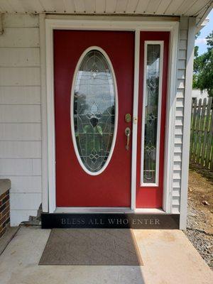 Painted steel front door with white trimming.