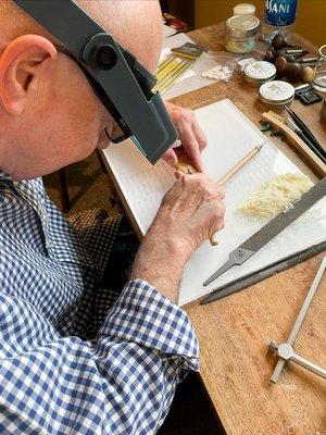 Pierre is carving a wax model for a pendant he designed.