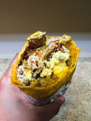 Breakfast burrito on a cheddar jalapeño tortilla with mixed cheese, potatoes, egg, bacon, sausage, mild pico, green sauce, and sour cream.