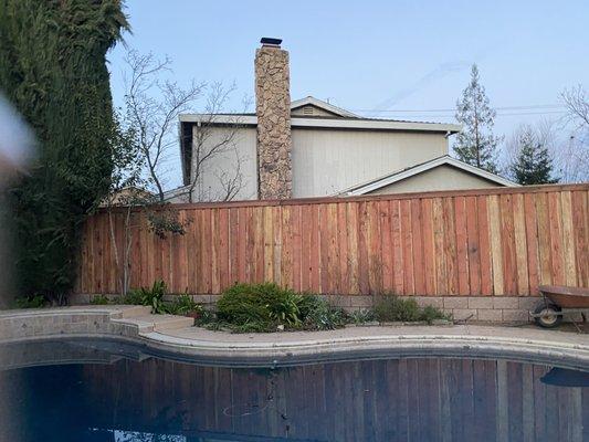 Redwood fence with retaining wall and cap