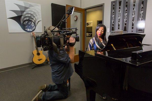 "BMORE Lifestyle" co-host Chardelle Moore tries out the baby grand piano in the Academy's recital room.