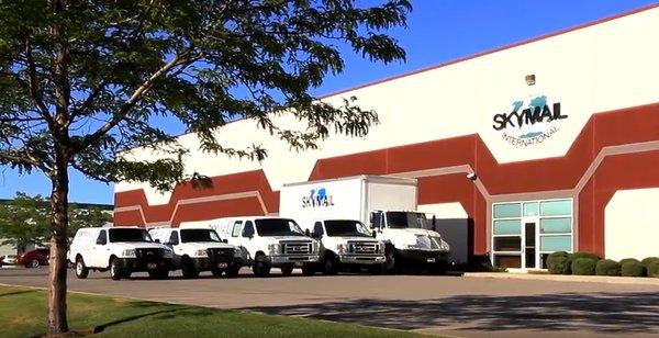 Outside of Skymail showcasing fleet of vehicles and warehouse.