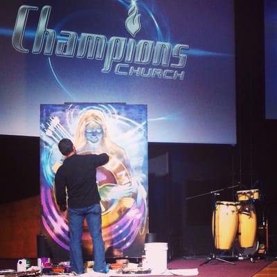 International artist Keith Goodson painting at Champions Church during worship.