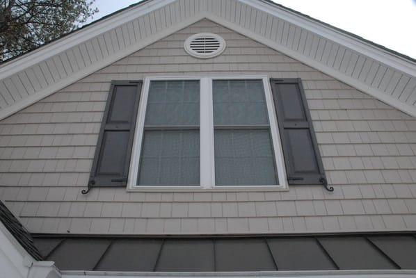 Energy Efficient Replacement windows with vinyl cedar shakes and paneled shutters.