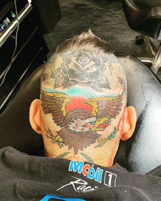 Tattoo of old school eagle back of the head .