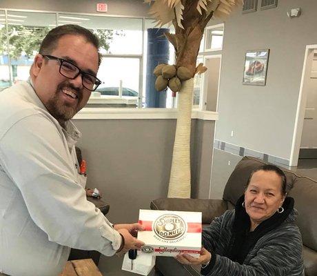 Body Shop Manager gifting some donuts to a customer.